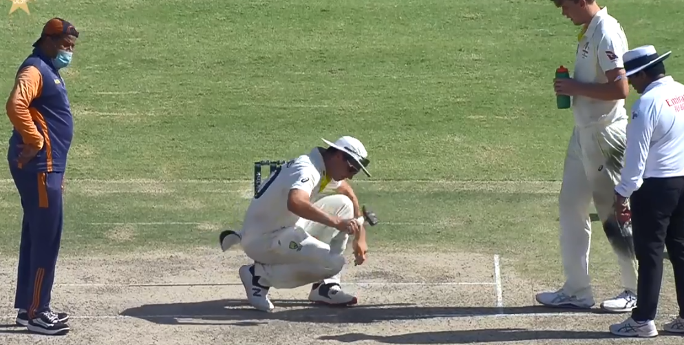 Aus vs Pak: Pat Cummins uses a hammer to try to level an uneven area of the Karachi pitch.
